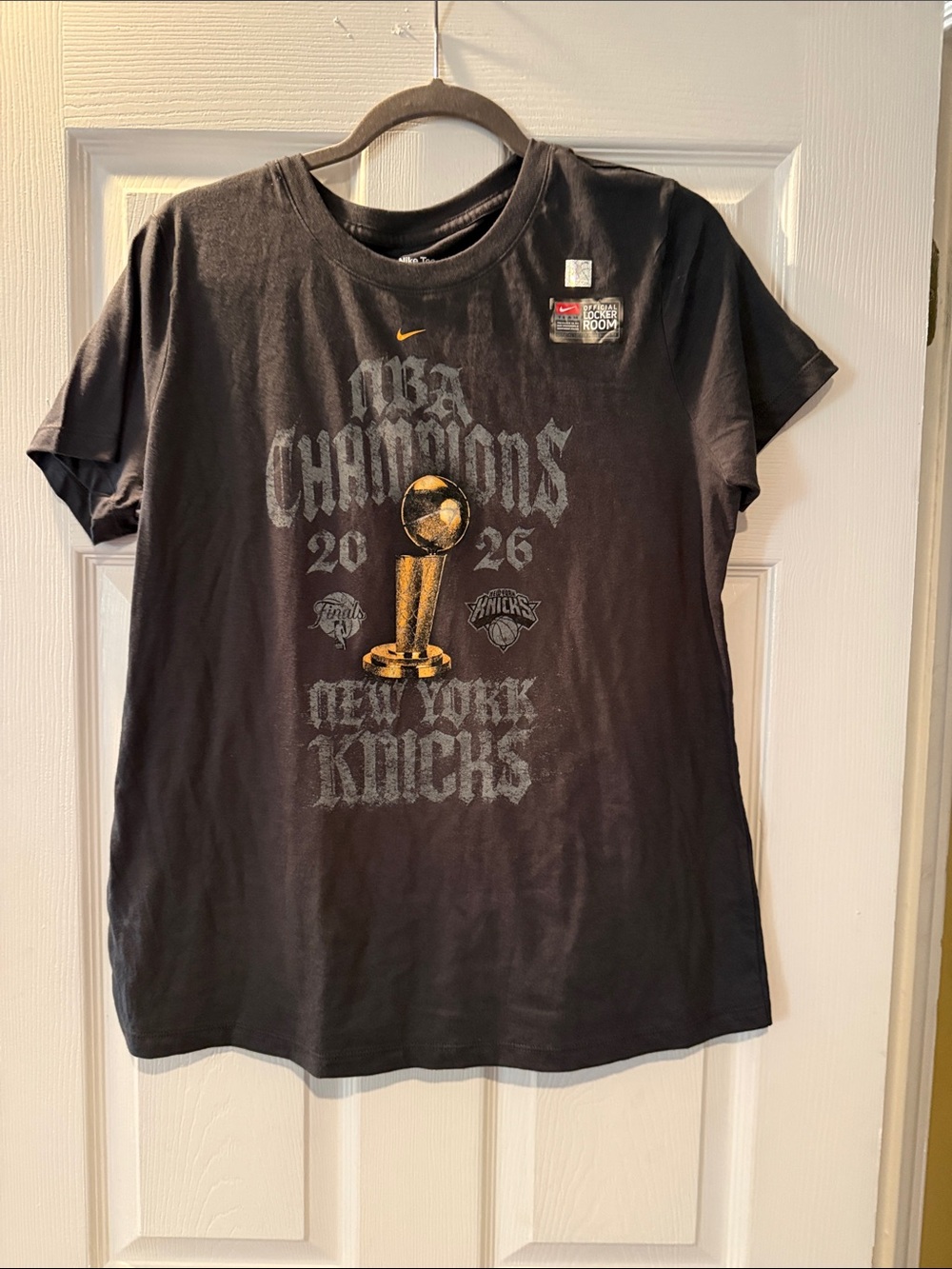 Nike Black New York Knicks 2026 Champions Graphic Tee with Gold Trophy